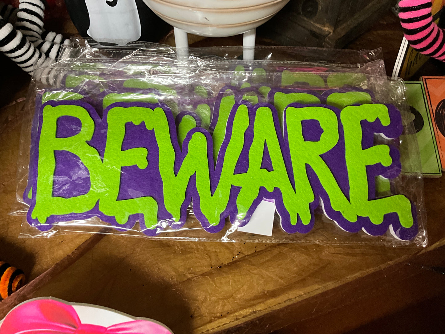 BEWARE sign, green letters purple background